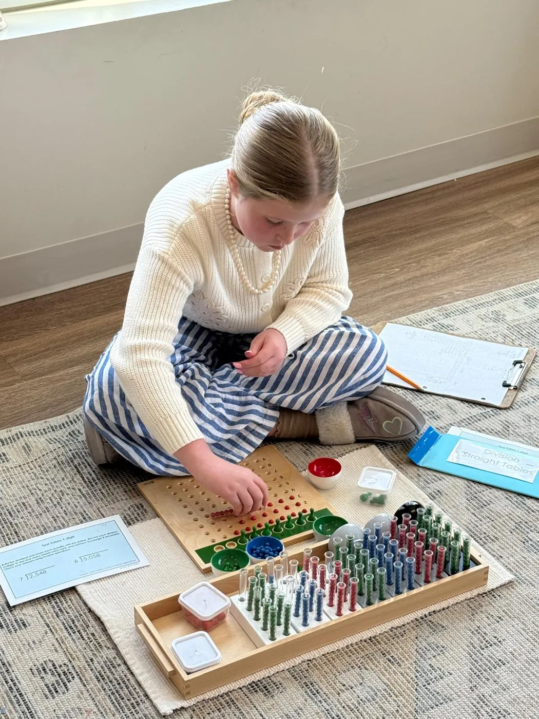 Elementary student working with Montessori math materials