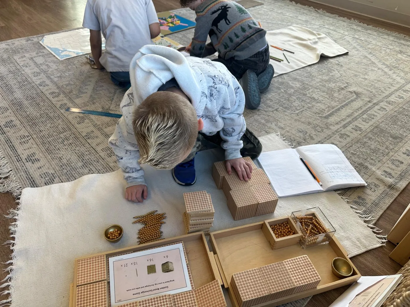 Students working with Montessori golden bead materials